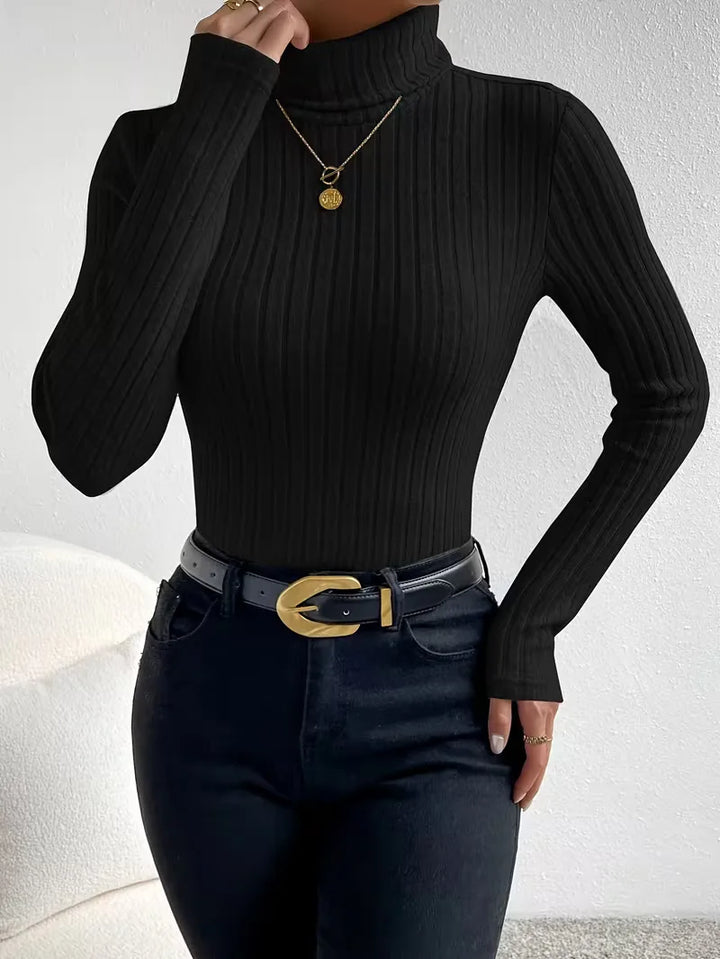 Model draagt een slimfit ribgebreide dames coltrui longsleeve. Modieus en comfortabel voor de winter.