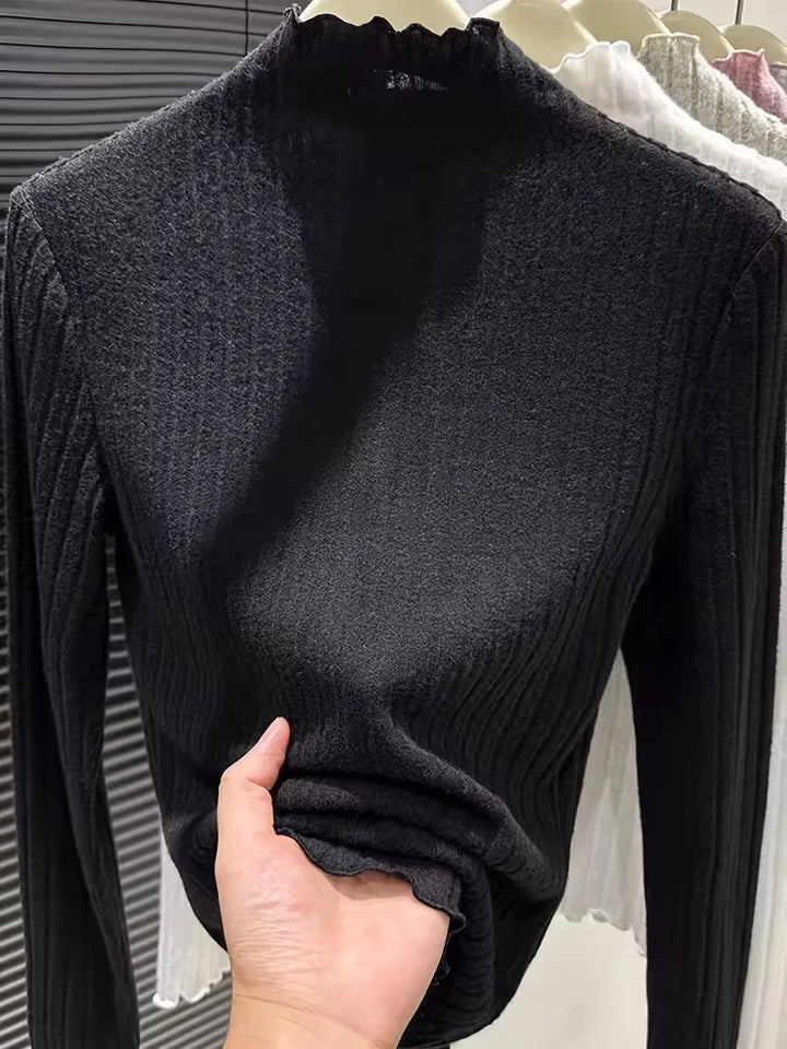 Ribbelstof dames longsleeve met geraffineerde mock halslijn en speelse ruches, zowel casual als chic.