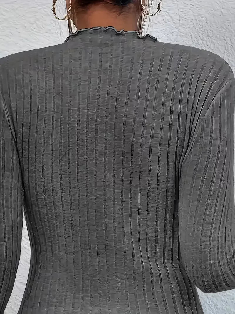 Veelzijdige dames top van ribstof, slim fit model met mock hals en elegante ruches details.