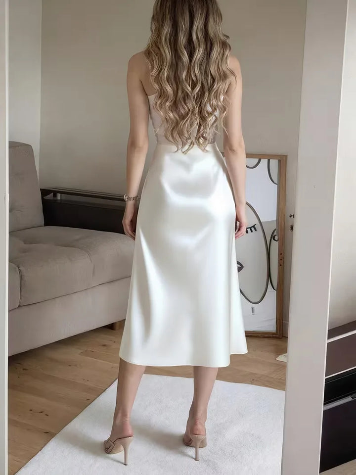 Crèmekleurige satijnen midi rok dames, stijlvol met hoge split en subtiele knoopjes.