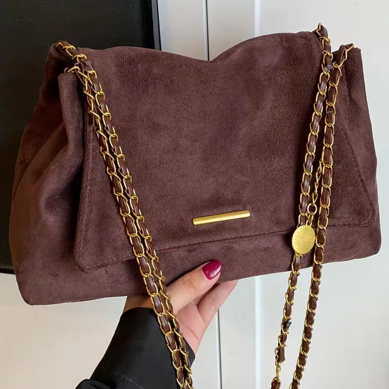 Dames schoudertas van faux suède met elegante gouden kettingband. Casual chic tas, perfect voor herfst/winter.