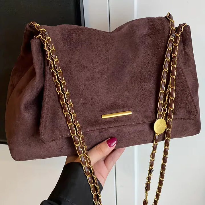 Dames schoudertas van faux suède met elegante gouden kettingband. Casual chic tas, perfect voor herfst/winter.