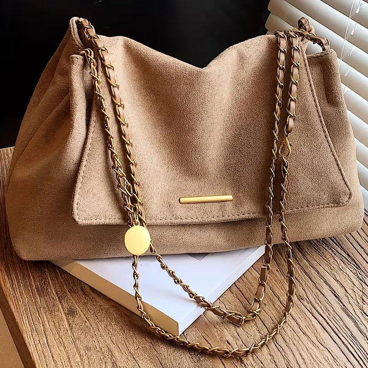 Compacte faux suède schoudertas voor dames, met verstelbare kettingband. Stijlvol en praktisch voor dagelijks casual chic gebruik.