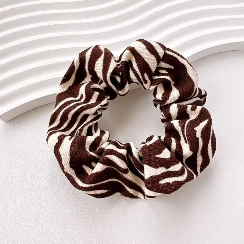 Zachte katoenen scrunchies voor dames met trendy dierenprint. Comfortabele en modieuze haaraccessoires.