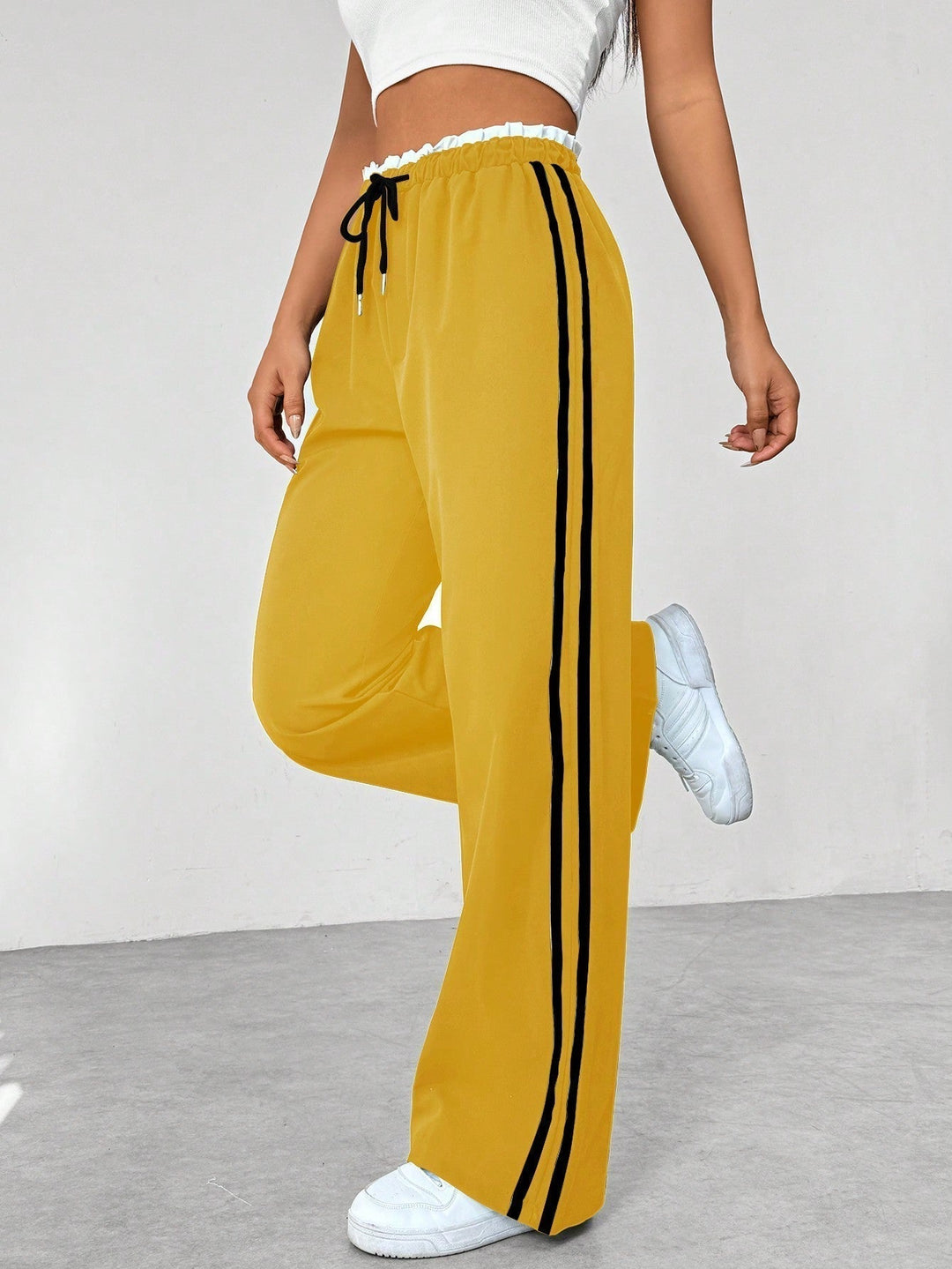 Trendy dameskleding: wide-leg broek met opvallende strepen, perfect voor een sportieve streetwear look.