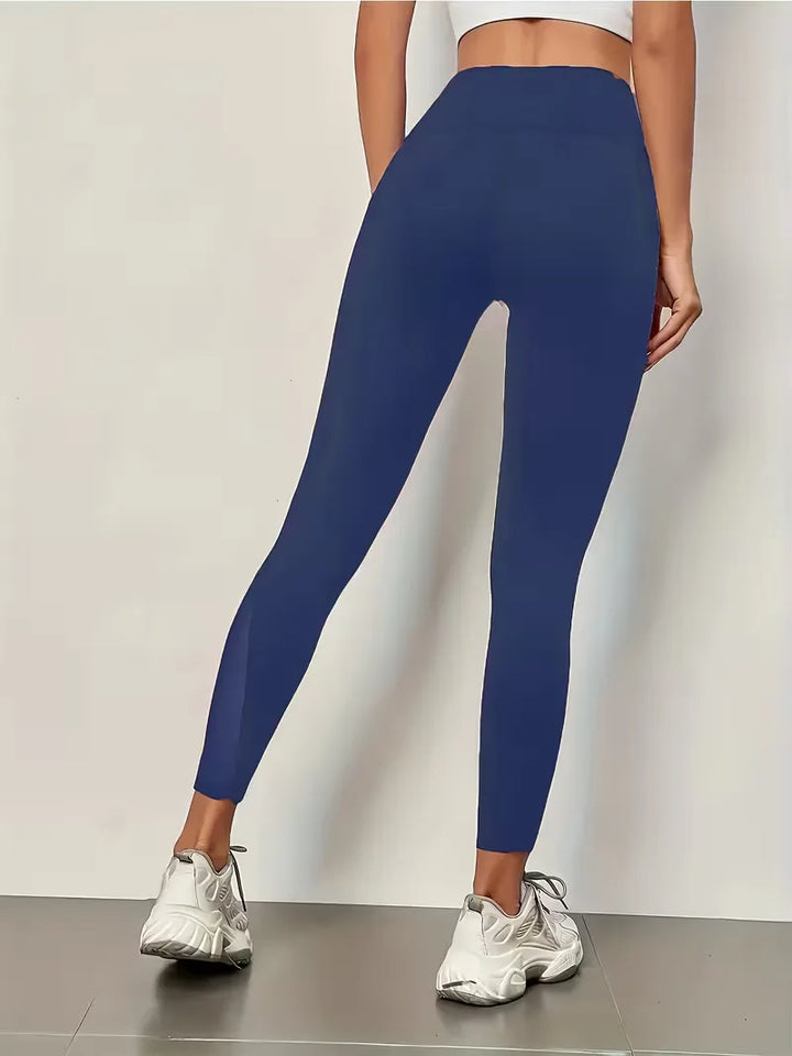 Zwarte dames yoga legging met hoge taille, ademende mesh panelen en zijzakken voor je essentials.