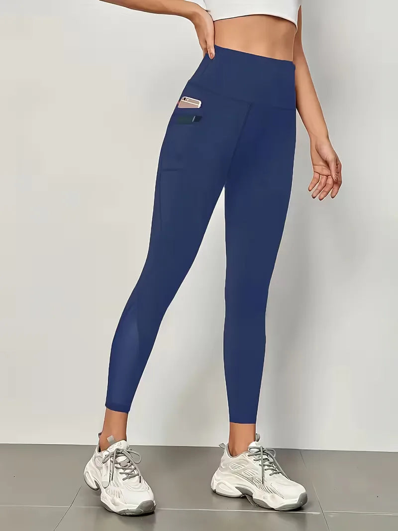 Marineblauwe dameslegging met hoge taille, mesh details en zijzakken, comfortabel voor casual en sport.