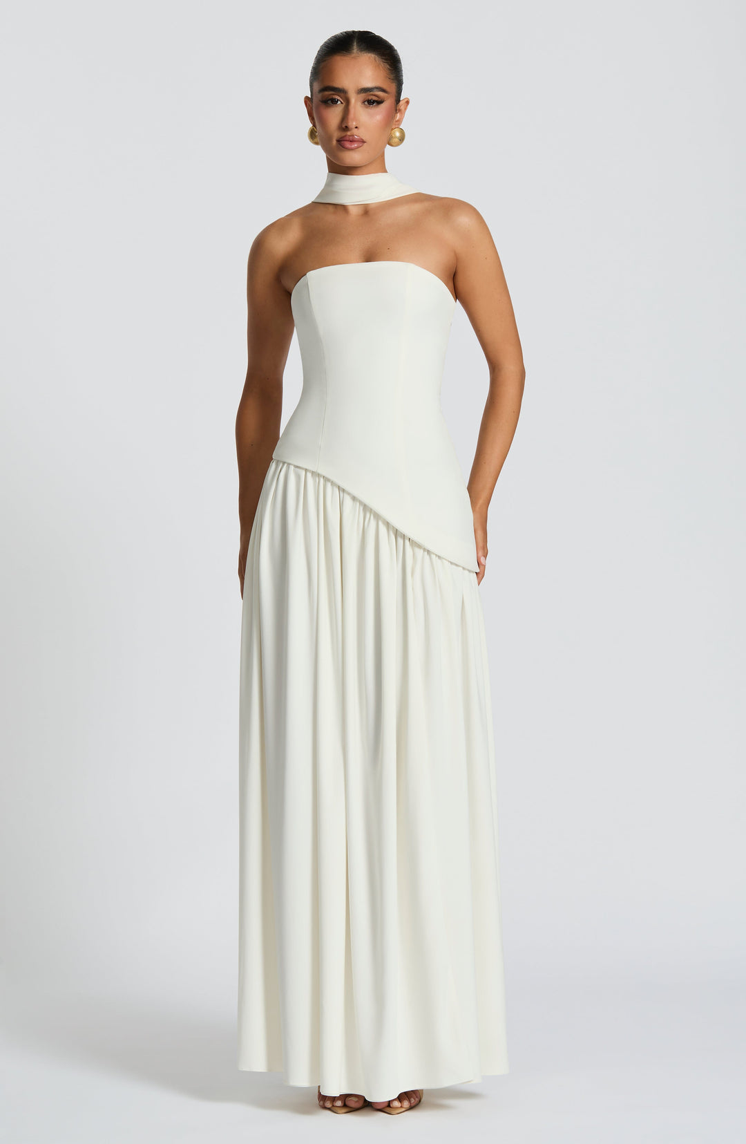 Feestjurk dames: strapless maxijurk met corset details en een opvallende asymmetrische taillelijn.