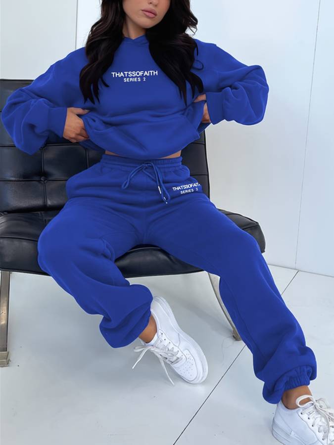 Gedragen dames joggingpak met comfortabele hoodie en rechte broek, perfect voor een casual en sportieve dag.
