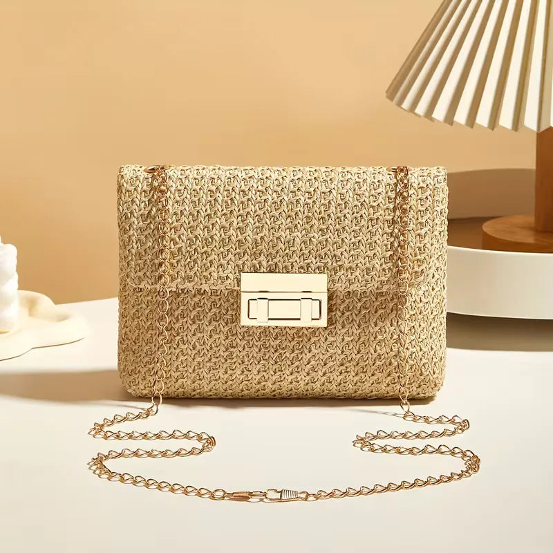 Dames stro schoudertas met gouden ketting, ideaal voor zomerse dagen aan het strand.