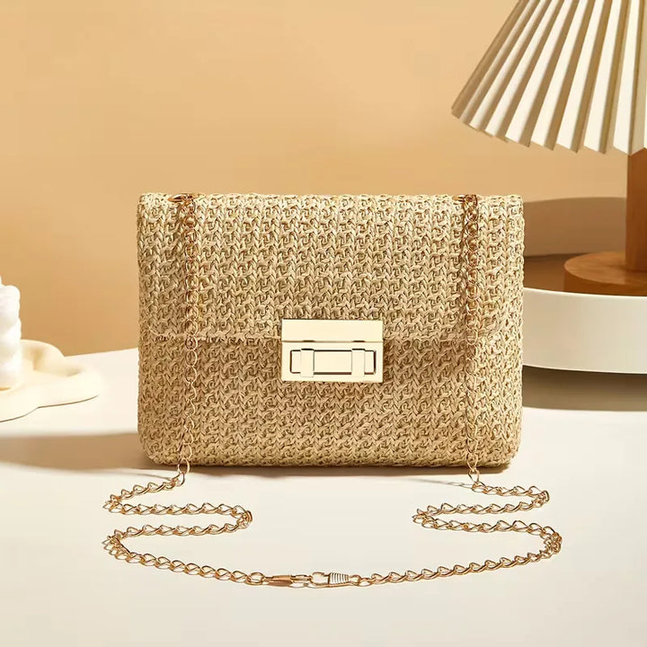 Dames stro schoudertas met gouden ketting, ideaal voor zomerse dagen aan het strand.