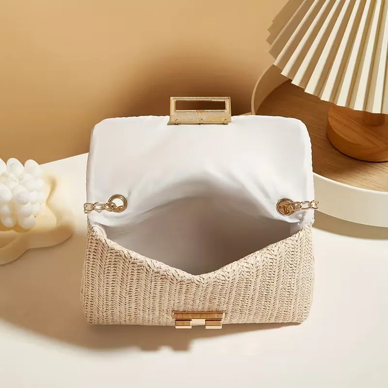 Casual dames handtas van gevlochten stro, afgewerkt met een trendy gouden ketting.