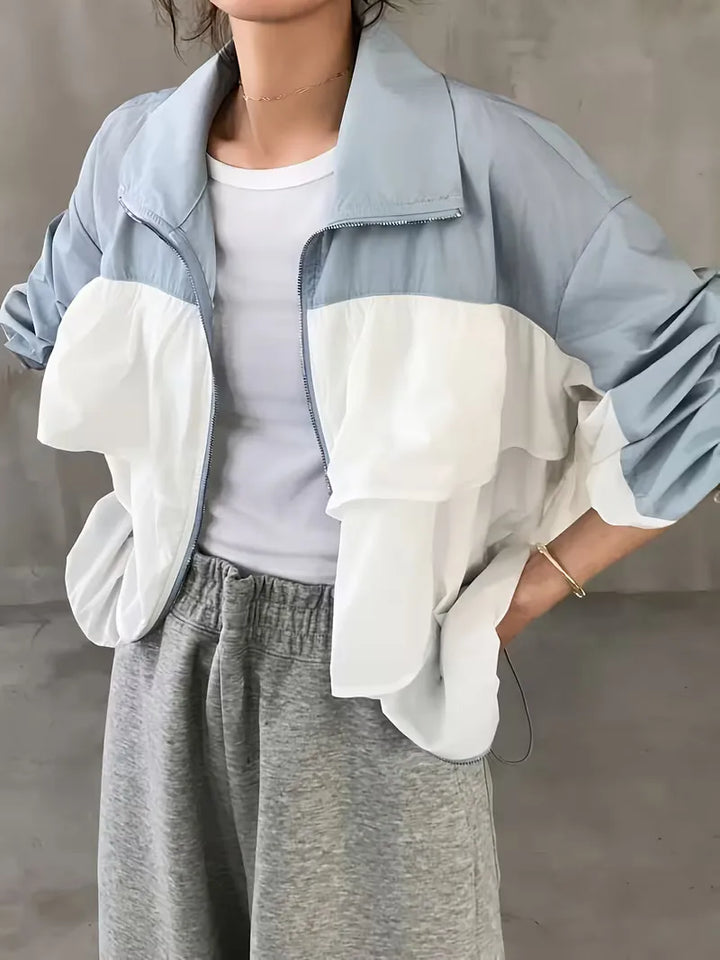 Dames trackjacket met capuchon in stijlvol lichtblauw en wit colorblock design, ideaal voor casual streetwear.