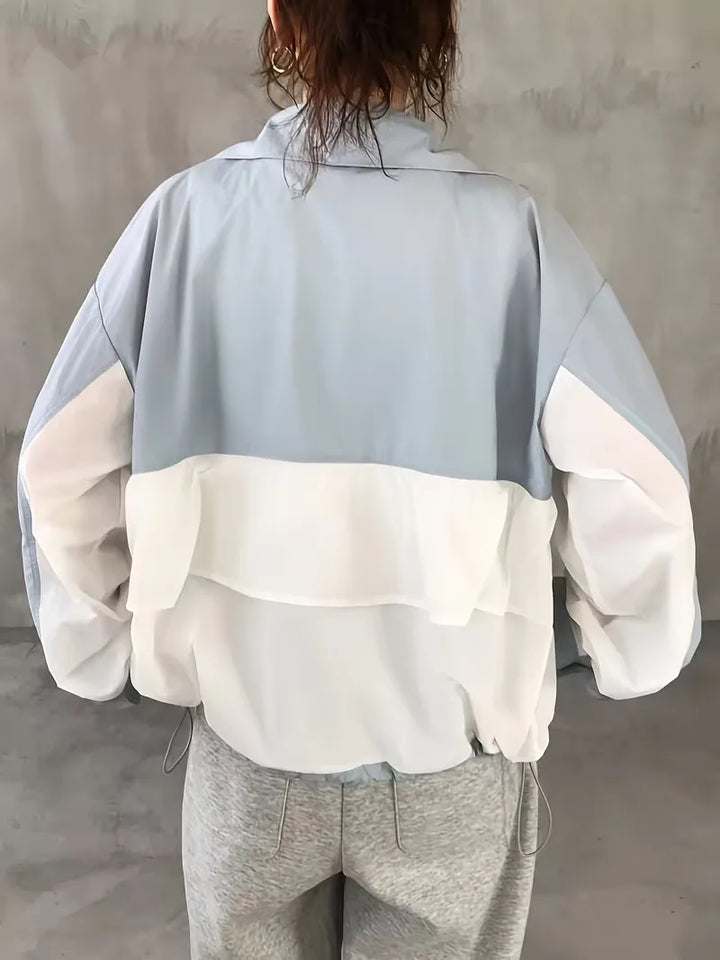 Veelzijdige dames trackjacket met capuchon, colorblock in wit en lichtblauw, comfortabel voor sport of streetwear.