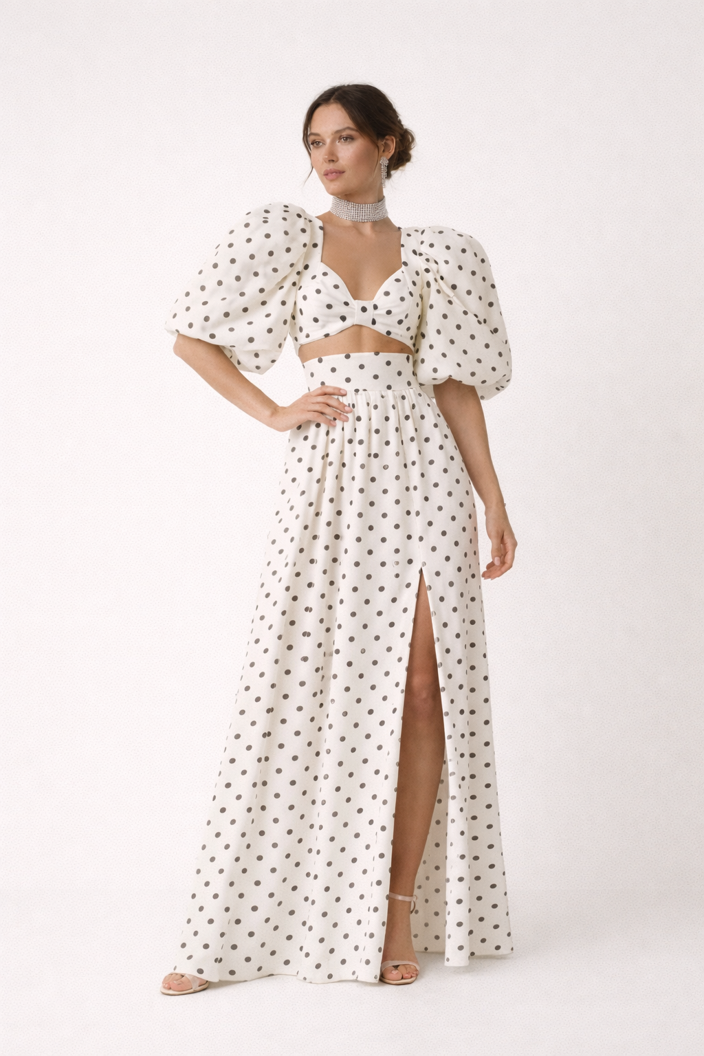 Elegante damestop met trendy pofmouwen en bolletjesprint, onderdeel van een zomerse tweedelige set.