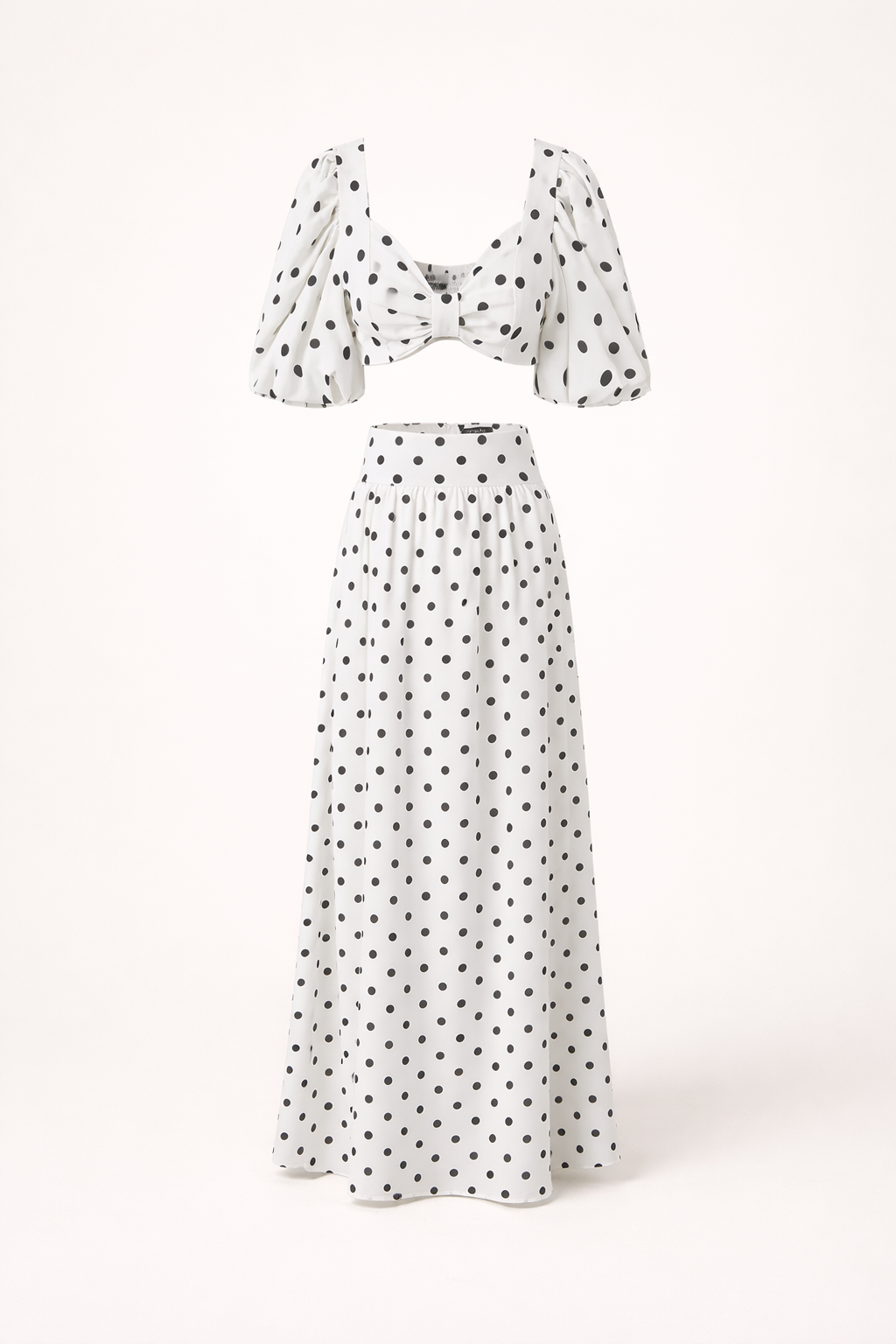 Zomerse feestkleding dames: elegante topset met pofmouwen en vloeiende maxirok met bolletjesprint.