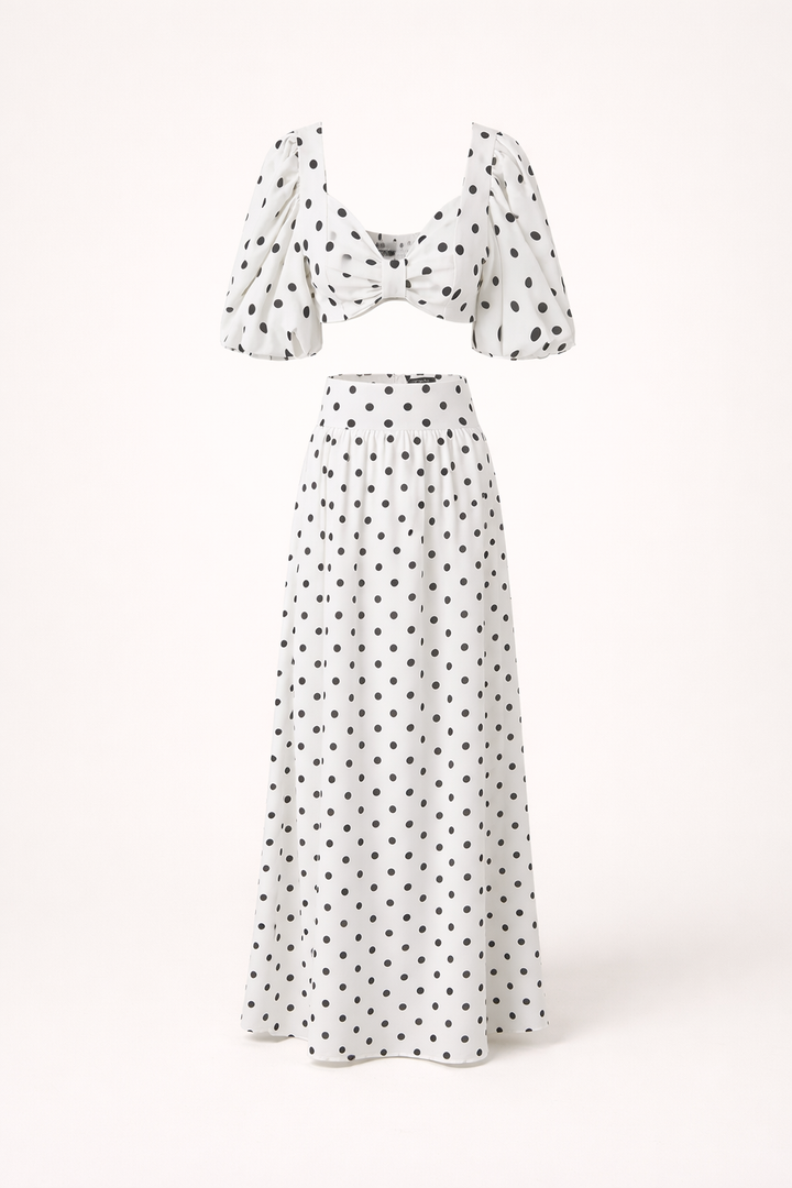 Zomerse feestkleding dames: elegante topset met pofmouwen en vloeiende maxirok met bolletjesprint.