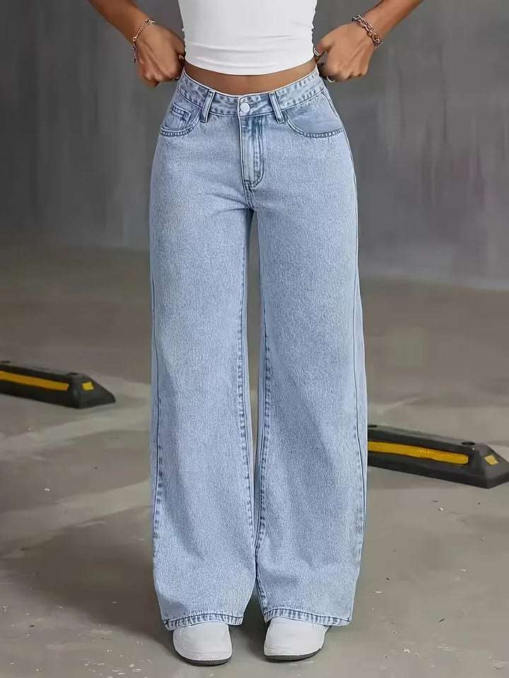 Model draagt lichtblauwe dames wide leg jeans met hoge taille, casual gestyled voor een moderne, comfortabele look.