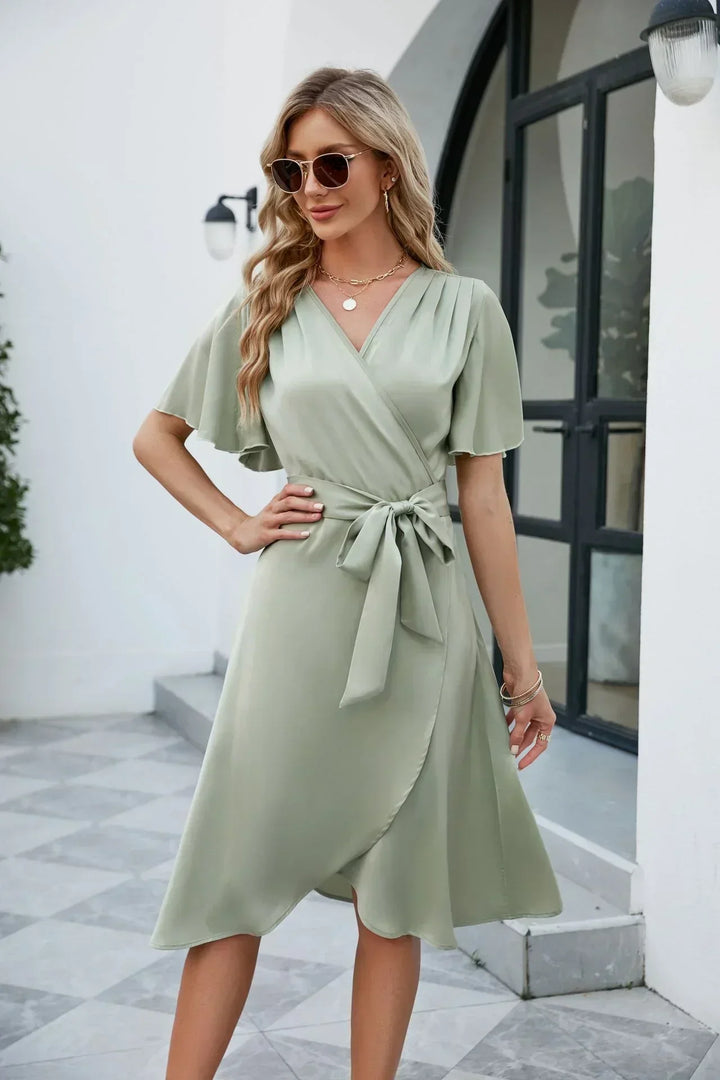 Dames wikkeljurk met korte mouwen en V-hals, ideaal als elegante zomerjurk of feestjurk.
