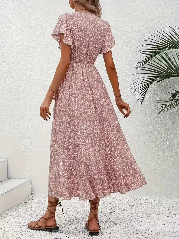 Levendige bloemenprint op deze dames wikkeljurk, perfect voor een stralende zomerse dag.