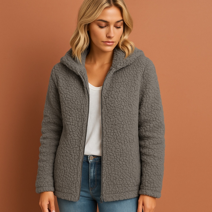 Model draagt een warm en stijlvol blauw dames wintervest met capuchon, comfortabele mode.