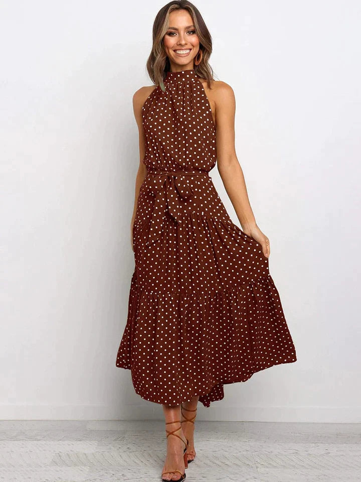 Deze modieuze damesjurk met stippenprint en halternek is de ideale zomermode voor elke gelegenheid.