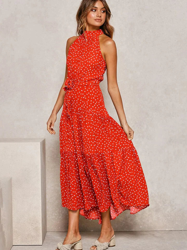 Vrouwelijke halterjurk met stippenprint en slim fit, een trendy keuze voor zomerse dagen en avonden.