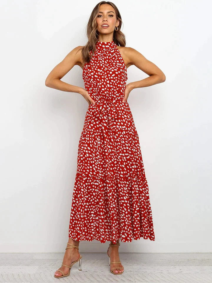 Zomerse damesjurk met vrolijke stippenprint en elegante halterhals. Combineert casual met chic.