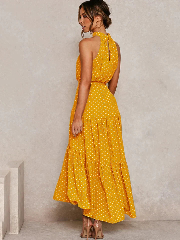 Vrouwelijke zomerjurk met trendy stippenprint en flatterende halterhals. Comfortabele pasvorm.