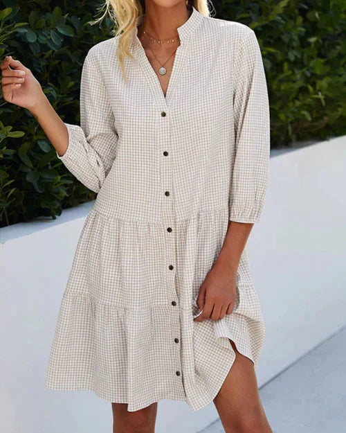 Stijlvolle dames midi jurk met uniek ruitpatroon, diepe V-hals en decoratieve knopen.