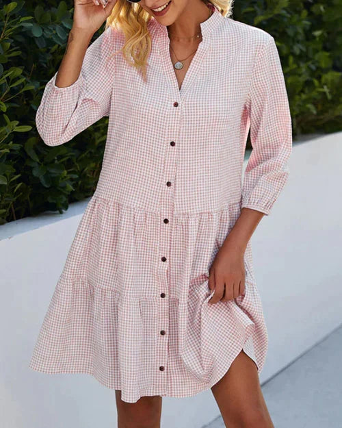 Elegante dames zomerjurk met opvallend ruitpatroon, V-hals en praktische knoopsluiting.