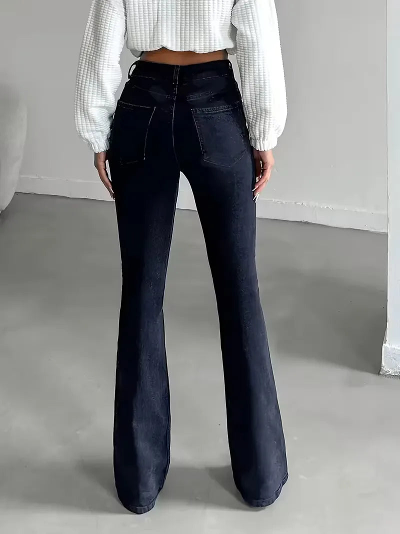Model draagt comfortabele donkerblauwe dames flared jeans met hoge taille en wijde pijpen, lente/zomer stijl.