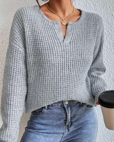 Detailopname van de gebreide Henley V-hals trui voor dames, met knoopsluiting en wafelstructuur, in grijs.