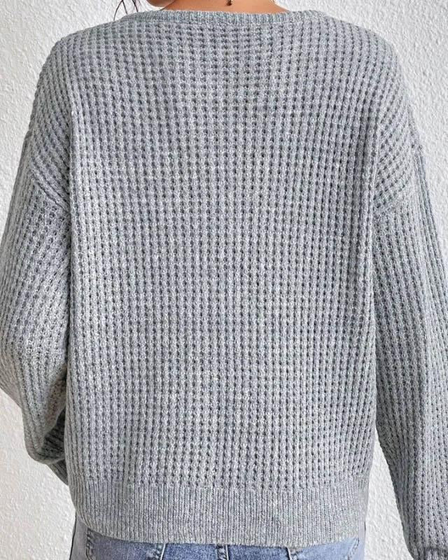 Model draagt een donkerblauwe gebreide Henley V-hals trui met lange mouwen, casual en comfortabel voor de winter.