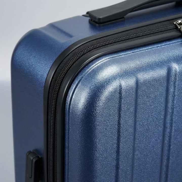 Stijlvolle donkerblauwe carry-on koffer met voorvak voor laptop en 4 soepele spinner wielen. Gemakkelijk reizen.