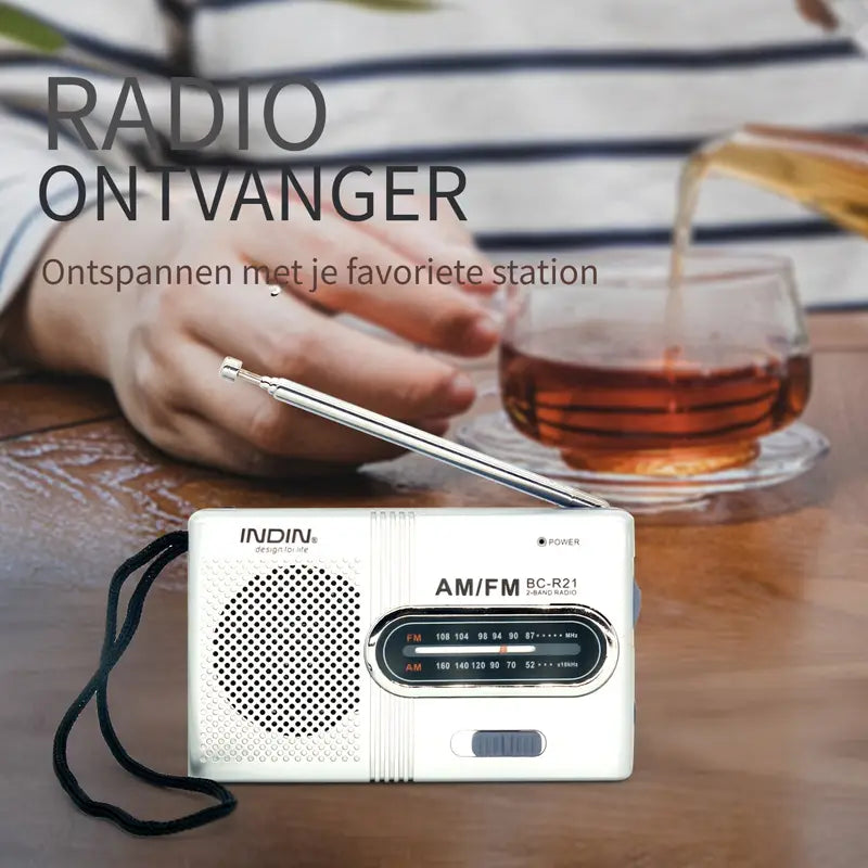 "Draagbare compacte AM/FM radio met stereoluidsprekers, telescopische antenne en eenvoudige bedieningsknoppen, zwart ontwerp.