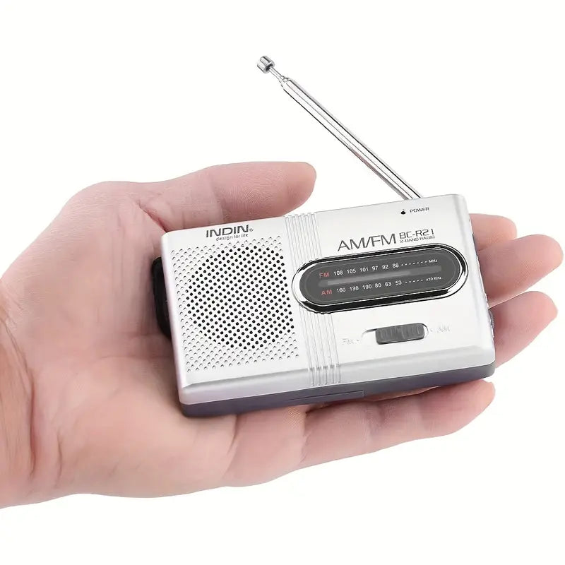 "Draagbare compacte AM/FM radio met stereoluidsprekers, telescopische antenne en eenvoudige bedieningsknoppen, zwart ontwerp.