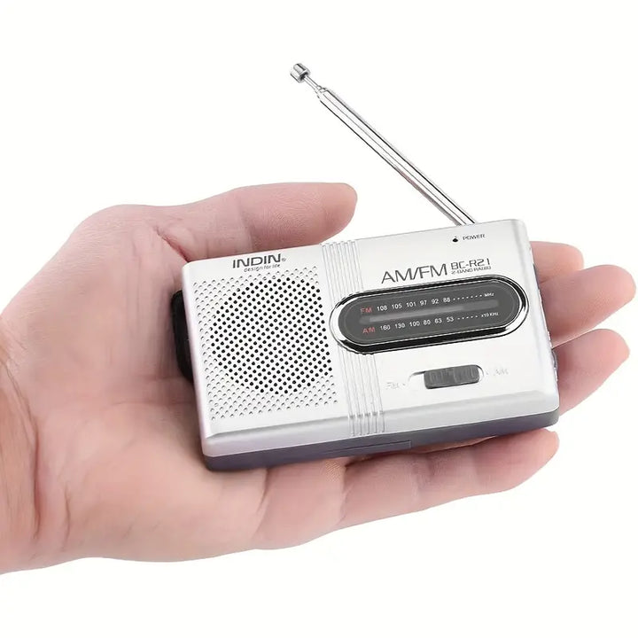 "Draagbare compacte AM/FM radio met stereoluidsprekers, telescopische antenne en eenvoudige bedieningsknoppen, zwart ontwerp.