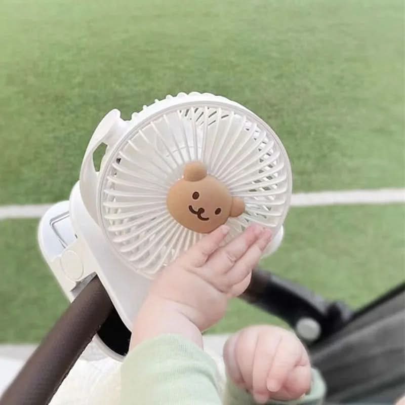 Witte draagbare clip ventilator bevestigd aan een strandstoel voor verkoeling buiten op een zonnige dag.