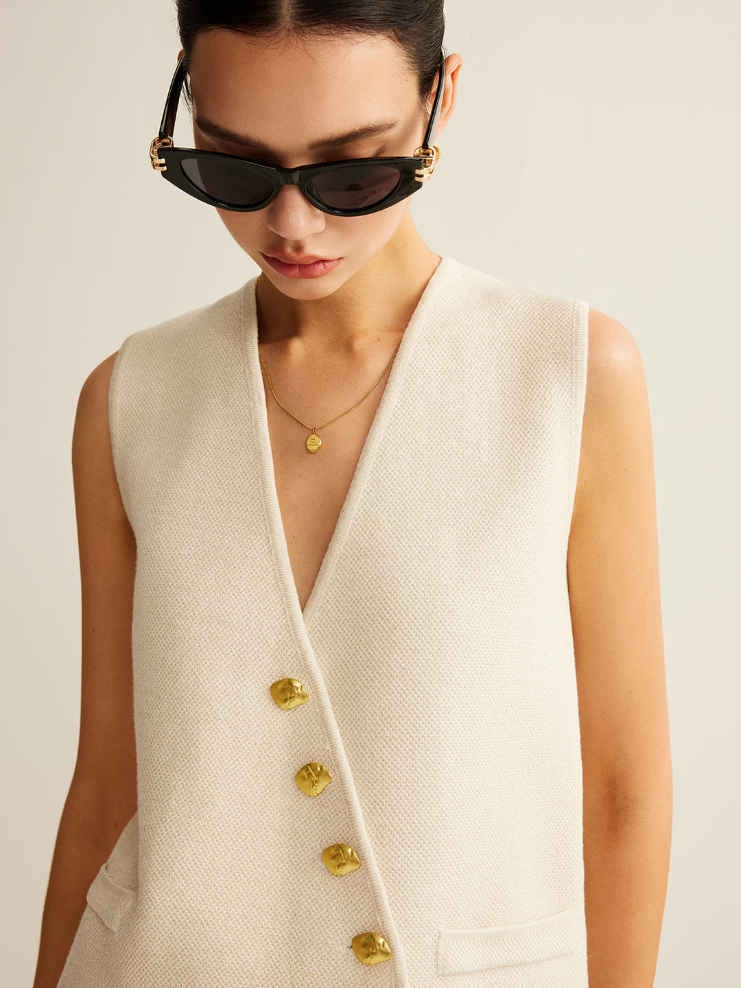 Gebreid damesvest met uniek asymmetrisch design en knopen, comfortabel en modieus in regular fit.