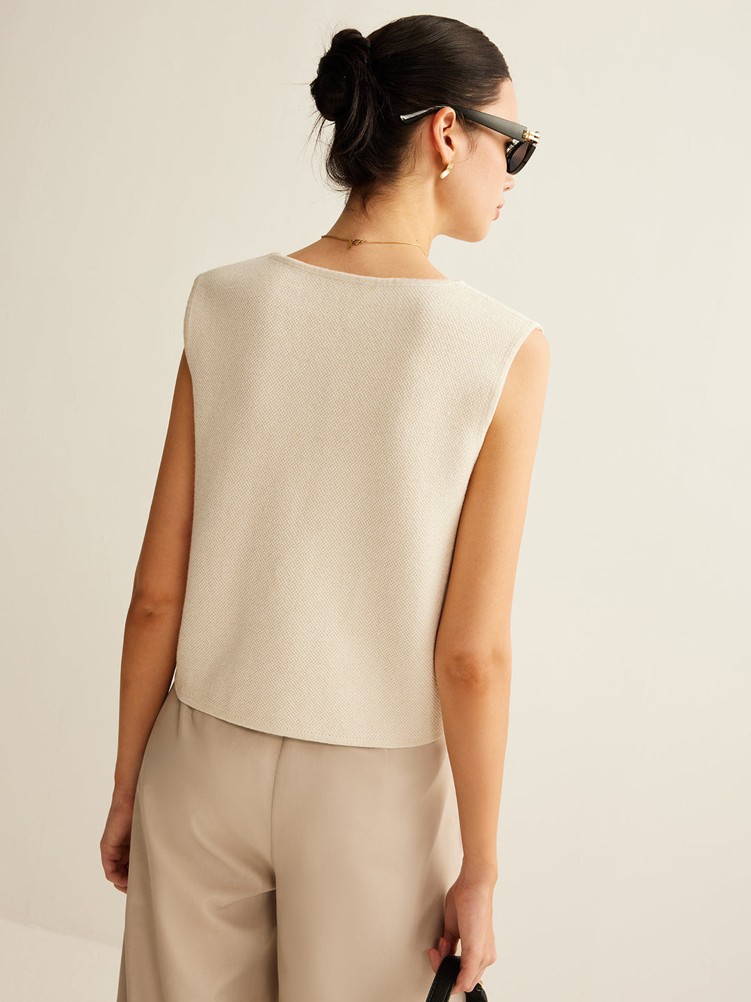 Veelzijdig gebreid damesvest met asymmetrisch detail en knopen, een elegante modekeuze voor elke outfit.