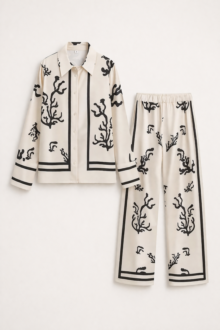 Comfortabele wijde broek met subtiele pioenroos print, onderdeel van een elegante damesset voor de zomer.