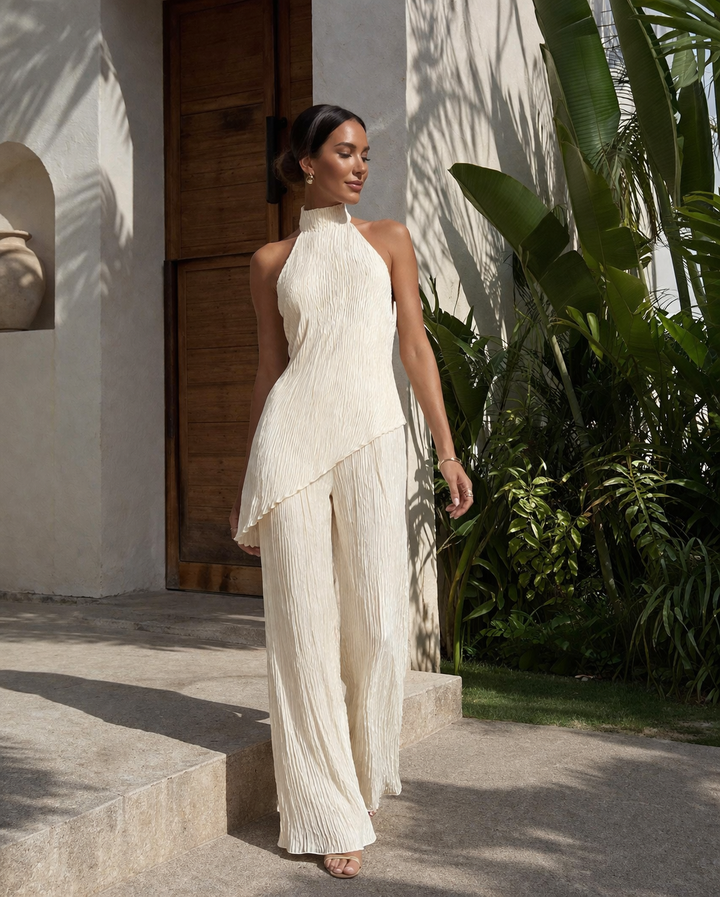 Stijlvolle beige dames tweedelige set met elegante geplooide haltertop en luchtige wijde broek, zomer klaar.