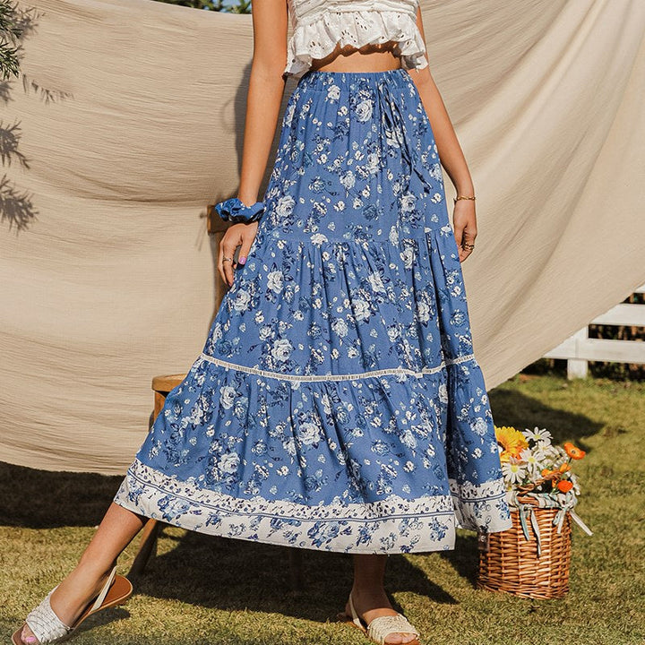 Elegante blauwe dames midirok met vloeiende bloemenprint; perfect voor lente en zomer. Hoge taille, wijde snit.