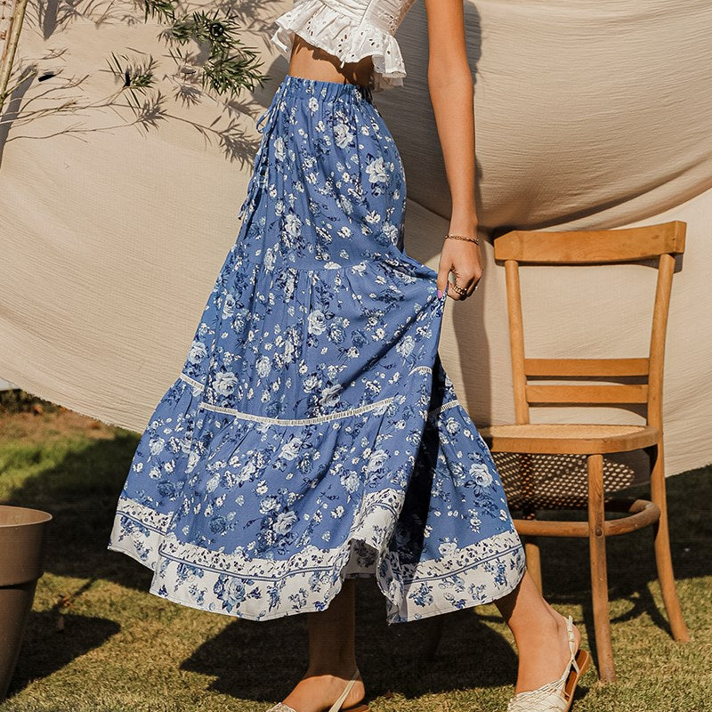 Close-up van de modieuze bloemenprint op de blauwe dames midirok. Vloeiend en casual voor lentemode.