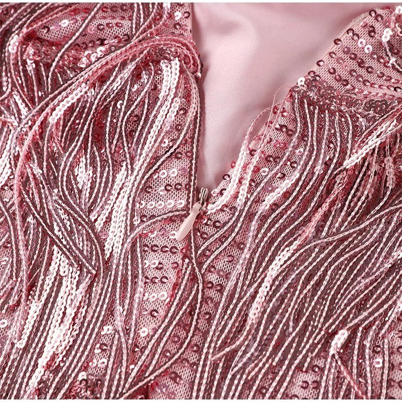 "Elegante cocktailjurk met franjes en veertjes, perfect voor feestjes, met aansluitende pasvorm en uitlopende rok."