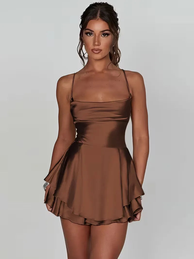 Elegante damesjurk met open rug, dunne spaghetti bandjes en een glanzende stof. Ideaal voor feesten.