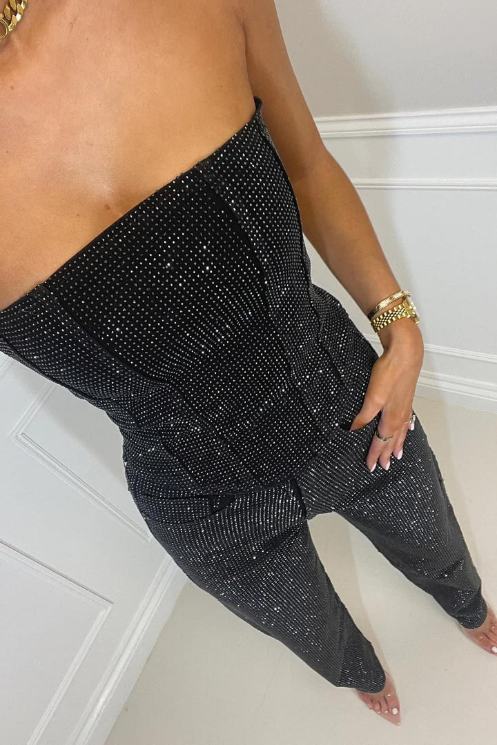 Sprankelende dames glitter jumpsuit, stijlvol en strapless, voor een opvallende feestoutfit.