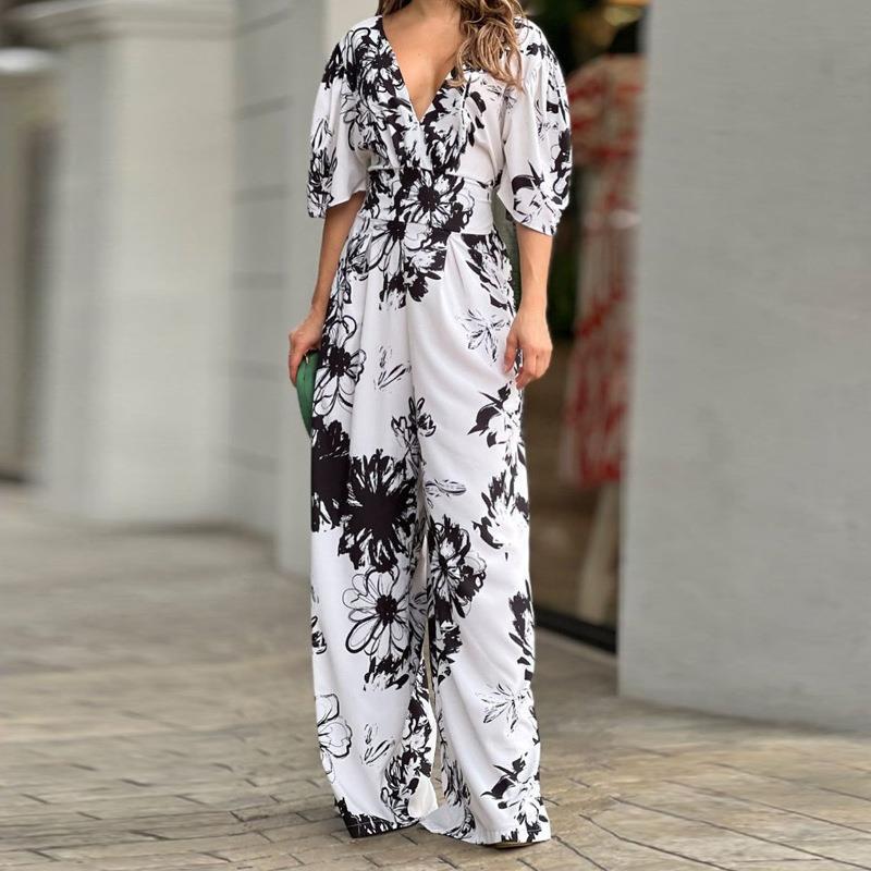 Modieuze gele dames jumpsuit met bloemenprint en wijde pijpen. Chique vrijetijdskleding voor de zomer.