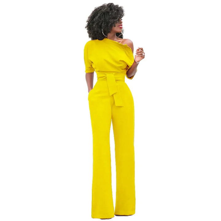 Dames avondjumpsuit met open schouder, strikband en wijde pijpen. Creëert een krachtige, elegante statement look.